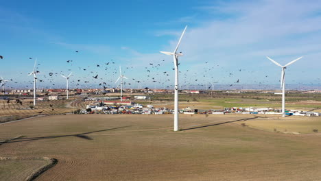Windkraftanlagen-Spanien-Mit-Einem-Vogelschwarm-La-Muela-Schrottplatz-Im-Hintergrund